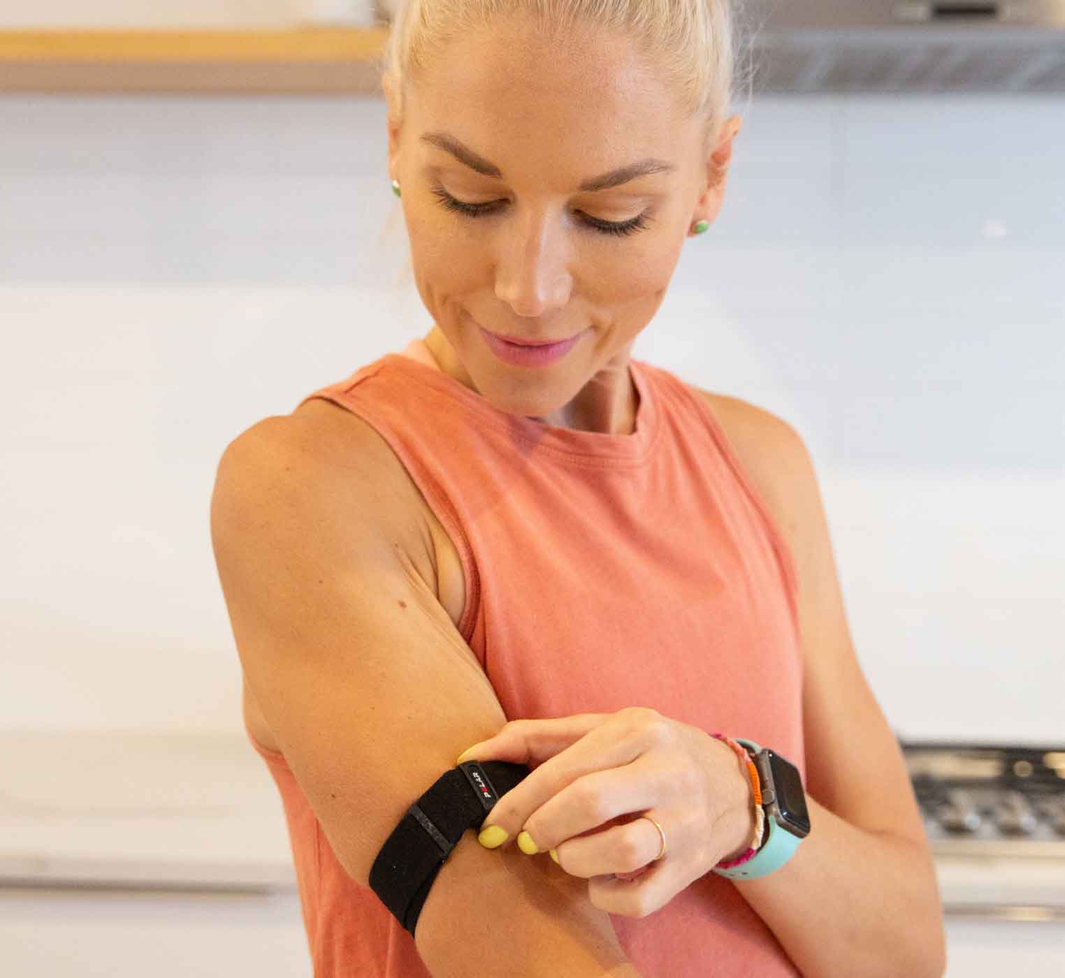 Woman turning her heart rate monitor that is around her forearm on